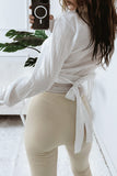 Bluse mit goldenen Verschlüssen und einem Gürtel weiß