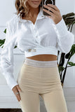 Bluse mit goldenen Verschlüssen und einem Gürtel weiß